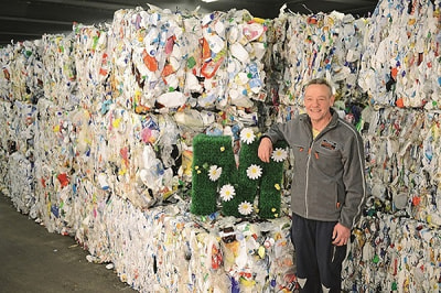 Mitarbeiter vor Recyclingmaterial Mitarbeiter vor Recyclingmaterial
